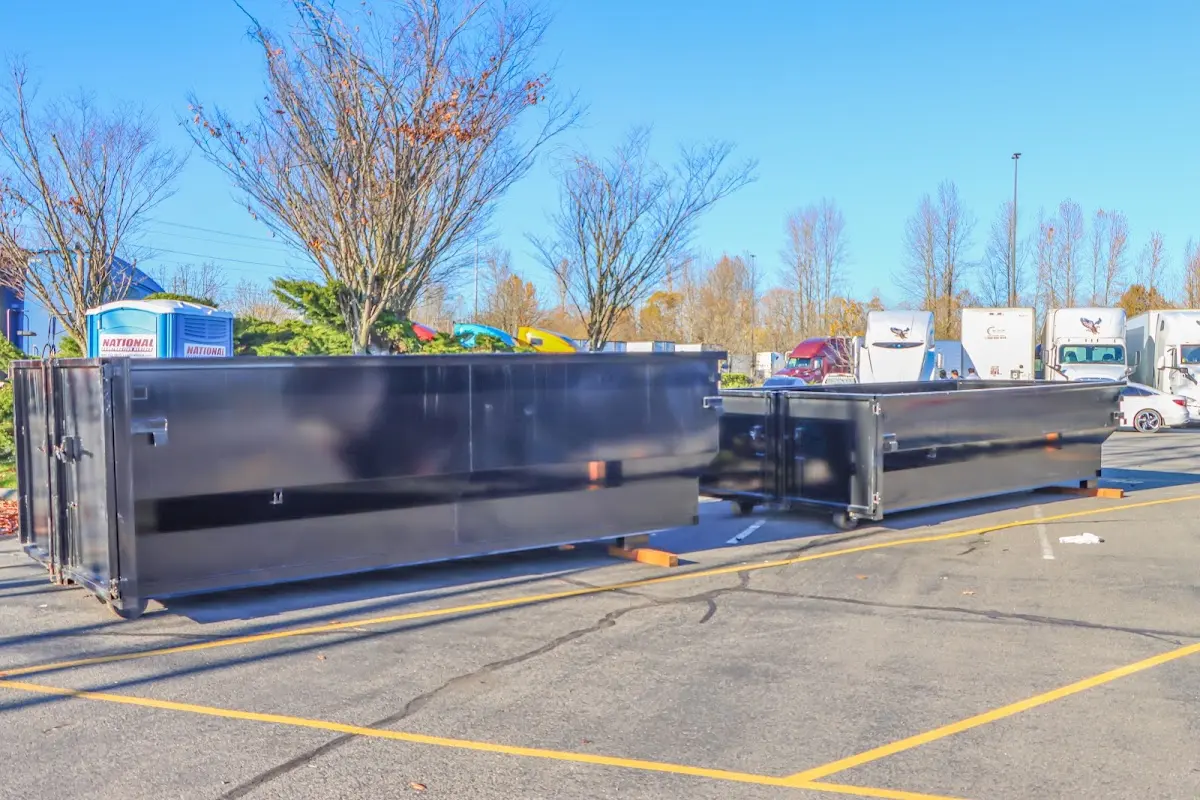 Professional dumpster rental service with roll-off container on residential driveway in College